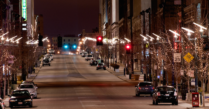 Streetlights on city street at night create glare making it hard to see.