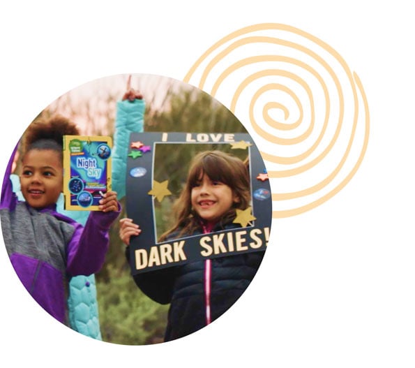 Photo of children holding signs reading "I LOVE DARK SKIES"