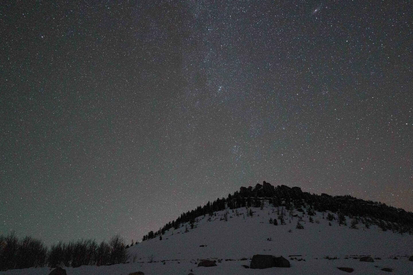 Starry sky over a snowy bluff.