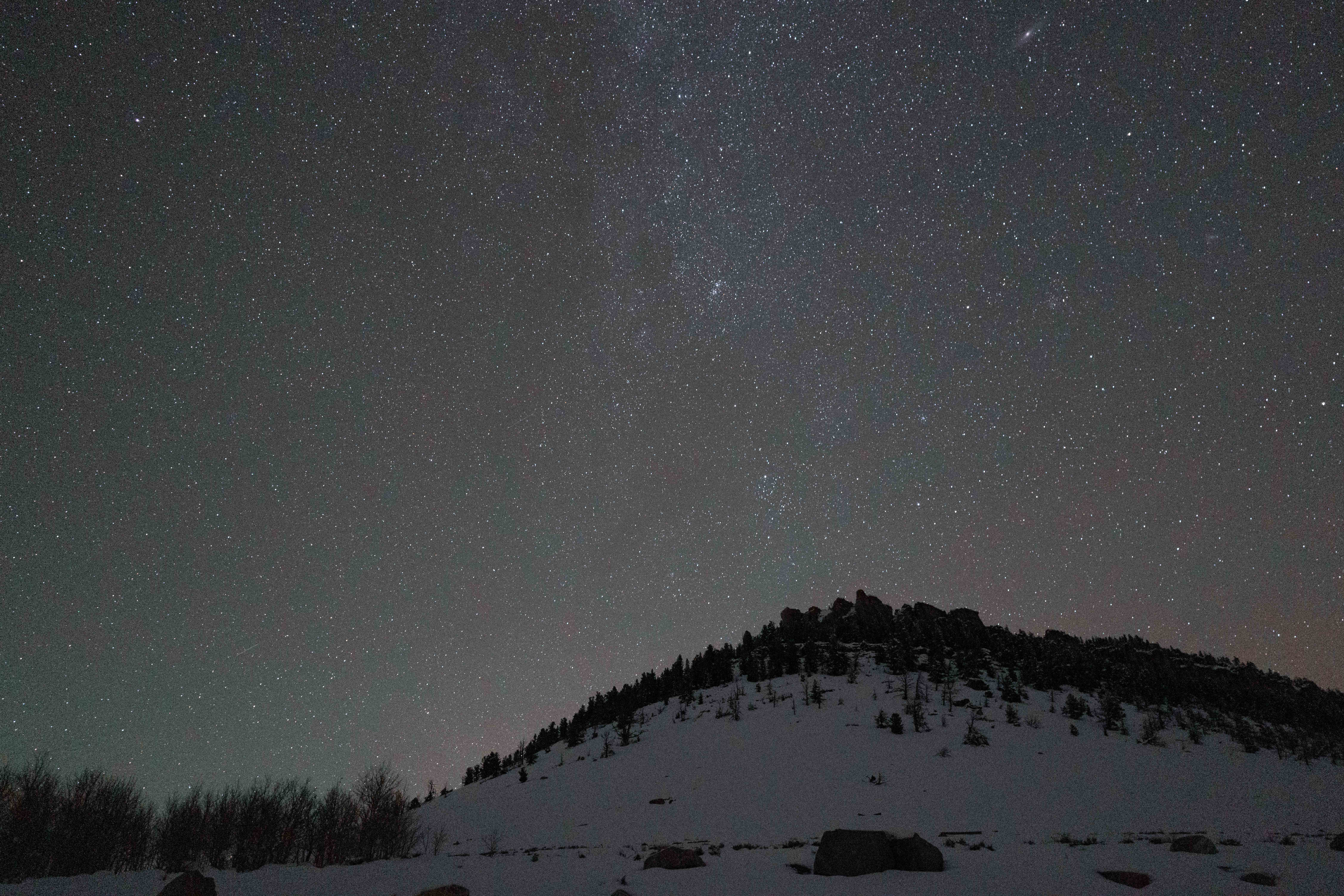 Starry sky over a snowy bluff.