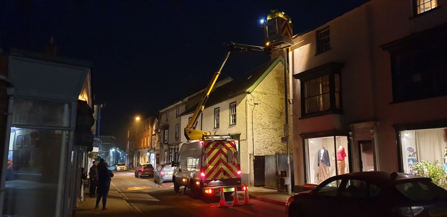 Works change a street light in the dark sky community of Prestegne, Wales.